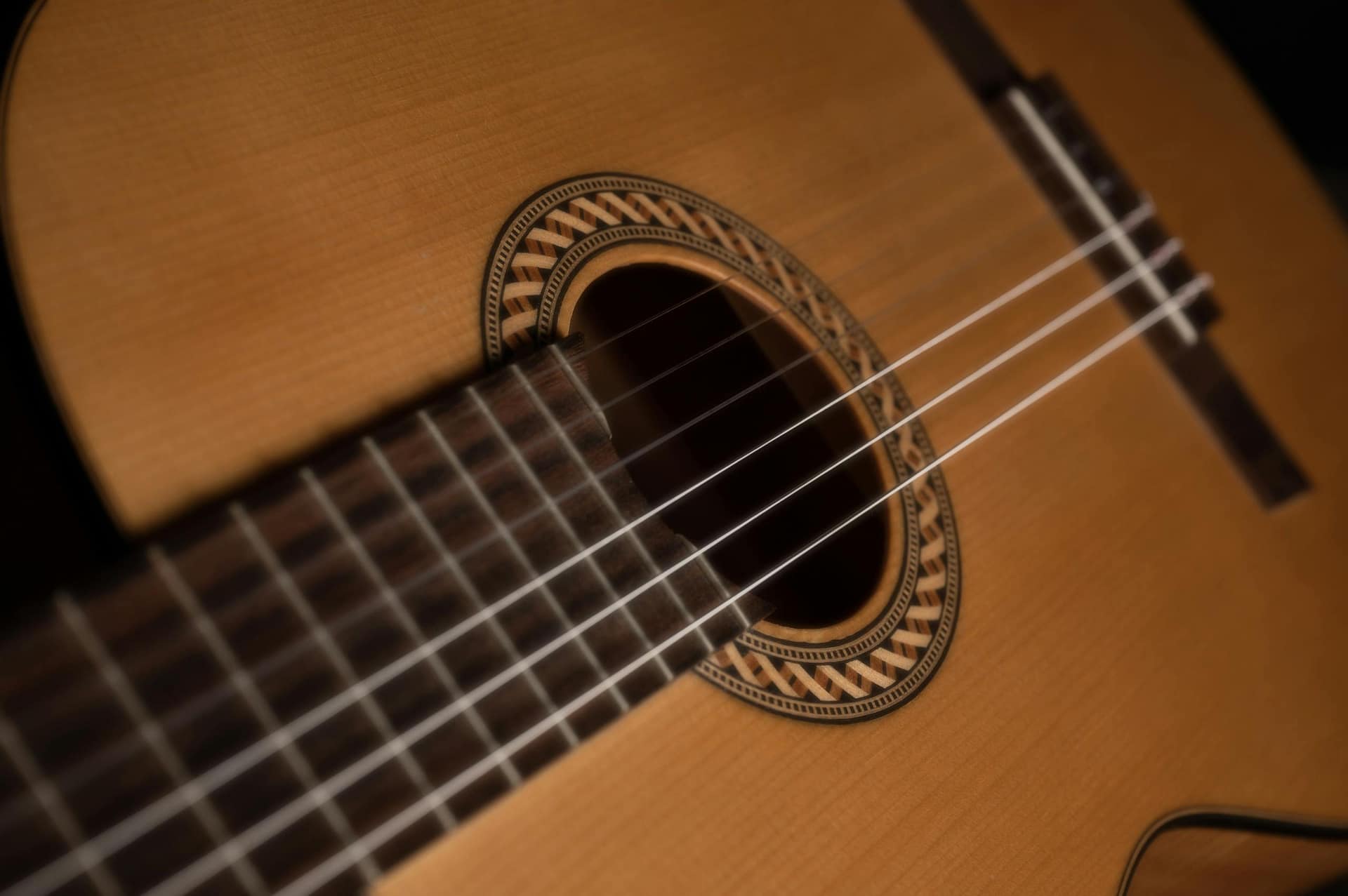 Detailed close-up of a classic acoustic guitar highlighting the strings and soundhole design.